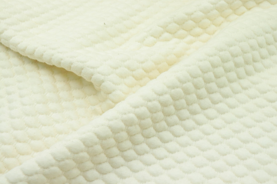 a close up of a white quilted material