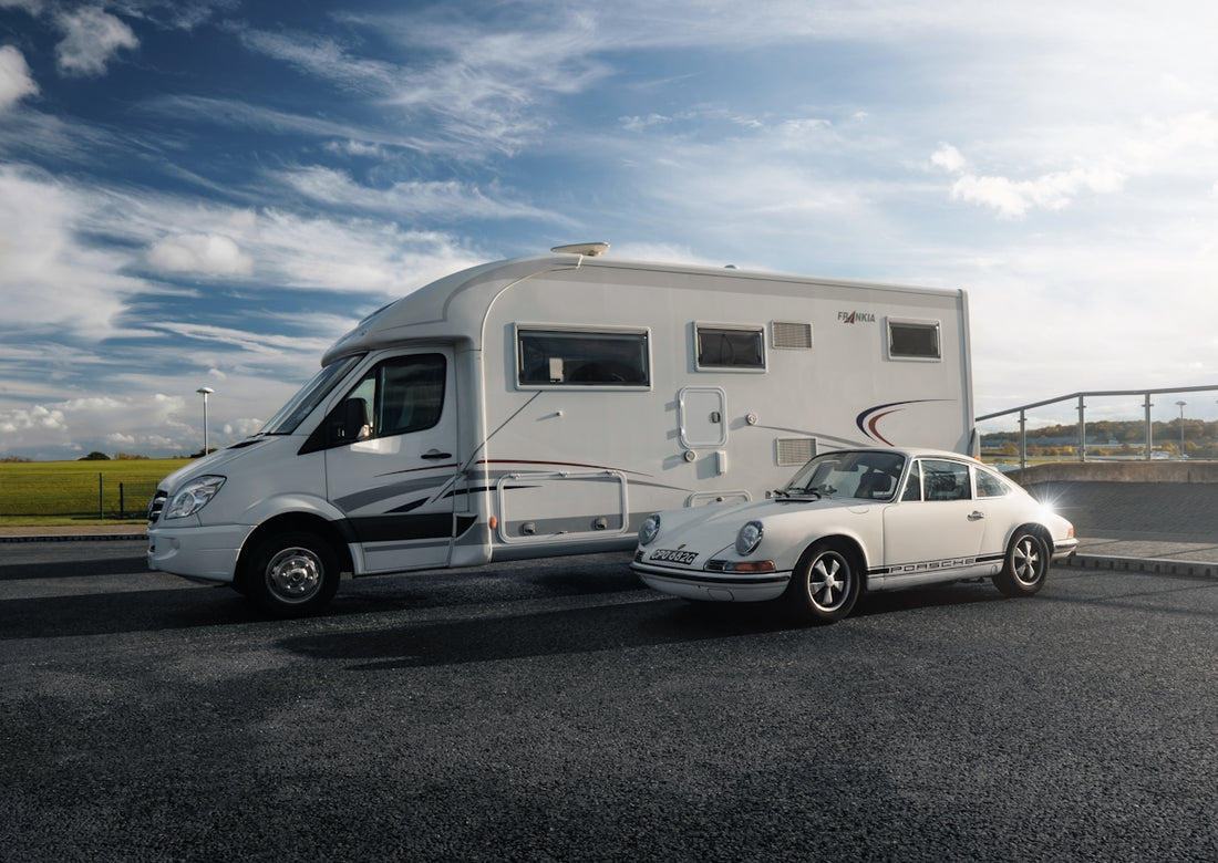 A white car is parked next to a trailer