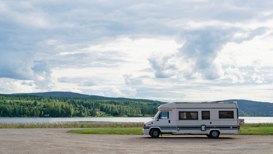 An rv parked in a parking lot next to a lake