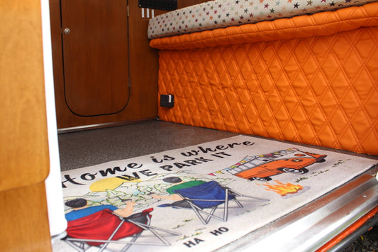 Interior of a camper van with a fun welcome mat.